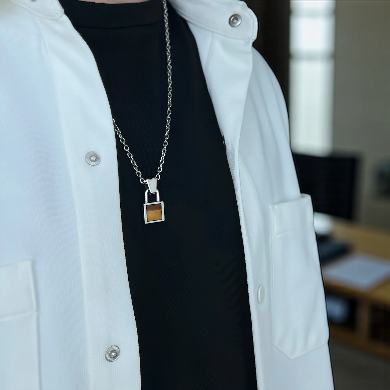 Lock of Resolve pendant on man with stainless steel chain and Tiger Eye stone