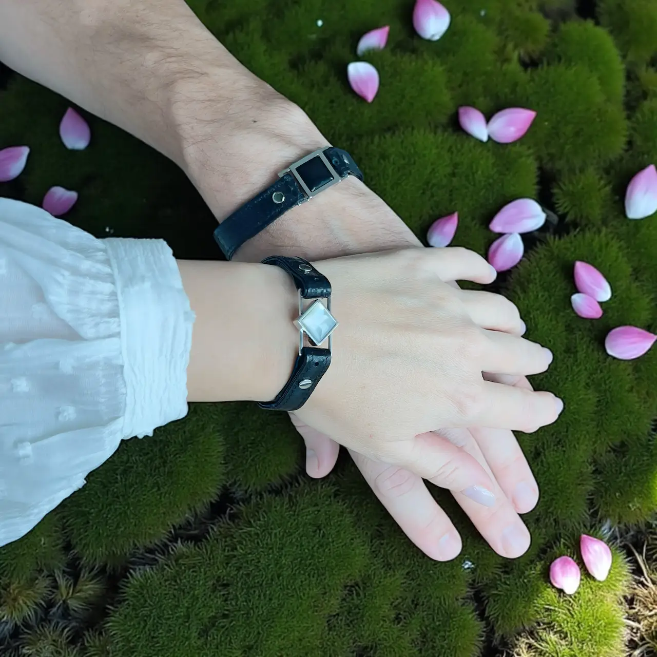 Matching couple bracelets with black and white natural stones shown on hands – symbolic Yin and Yang jewelry from Jewel Cocktail